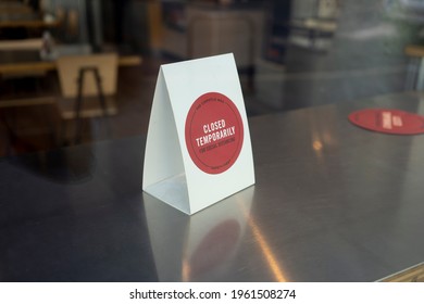 Portland, OR, USA - Apr 18, 2021: Closed Temporarily Table Card Is Seen In A Chipotle Restaurant In Downtown Portland Through The Storefront Window. The Place Is Open For Takeout And Delivery Only.