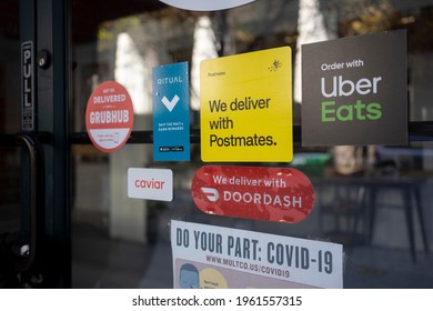 Portland, OR, USA - Apr 18, 2021: Various Food Delivery Service Options - DoorDash, Postmates, Uber Eats, Ritual, Caviar, And Grubhub - Are Seen Advertised At The Entrance To A Restaurant In Portland.