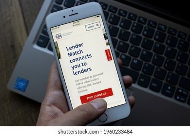 Portland, OR, USA - Apr 21, 2021: A Man Tries To Find A Lender For PPP Loan From The U.S. Small Business Administration (SBA) Website On His Phone.