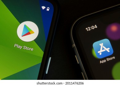 Portland, OR, USA - Apr 21, 2021: Google Play Store and Apple App Store icons are seen respectively on a Google Pixel smartphone and an iPhone. Google Play vs Apple App Store concept.
