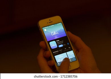 Portland, OR, USA - Apr 22, 2020: A Woman Checks The Calm Mobile App From The App Store On Her IPhone. Calm Is An Application For Sleep And Meditation.