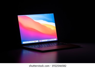 Portland, OR, USA - Feb 22, 2021: The new MacBook Air with Apple's M1 chip and the latest macOS Big Sur isolated on a desk in the dark.