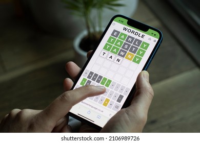 Portland, OR, USA - Jan 14, 2022: A woman plays Wordle on its official website on her iPhone. The word game developed by Josh Wardle has become the most recent social media and pop culture phenomenon.