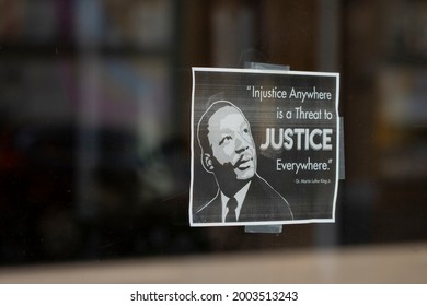 Portland, OR, USA - July 4, 2021: A Printed Sign That Promotes Social Justice By Quoting A Motto From Martin Luther King Jr. Is Seen On A Storefront Window In Portland, Oregon.