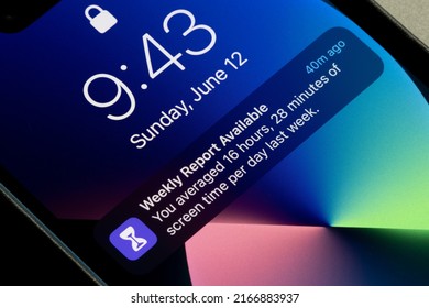 Portland, OR, USA - June 12, 2022: Weekly screen time report notification is seen on the lock screen of an iPhone. Screen addiction and harmful side effects of excessive screen time concept.