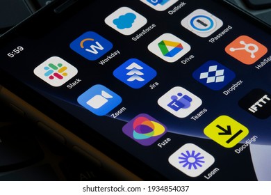 Portland, OR, USA - Mar 12, 2021: Slack app is seen on an iPhone with other apps that can be integrated with Slack, such as Workday, Salesforce, Zoom, Jira, Google Drive, 1Password, Fuze, and Teams.