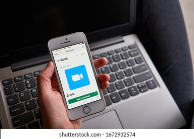 Portland, OR, USA - Mar 14, 2020: A Woman Tries To Create A Zoom Meeting In Slack From Her Smartphone. Zoom And Slack Technologies Are Collaborating To Facilitate Team Communication And Productivity.