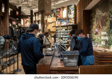 Portland, OR, USA - Nov 24, 2021: The checkout lane in the MUJI store in downtown Portland, Oregon, during the holiday season. Masked employees are seen behind plexiglass screens amid the pandemic.