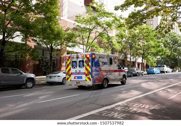 Portland, OR, USA - Sep 13,\
2019: An American Medical Response (AMR) ambulance responds to an\
emergency using lights and siren in downtown Portland,\
Oregon.