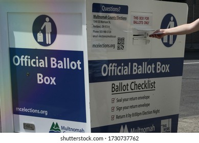 Portland, Oregon / United States - May 13, 2020: Voter Drops Off Mail In Ballot At An Official Election Ballot Drop Box.