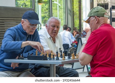 Portland, Oregon USA - April 20, 2015:  Three Old Retired Men Playing An Intense Game Of Chess At A Park On An Outdoor Table With A Timer