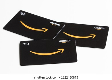 Portland, Oregon, USA - Jan 20, 2020: Three Amazon.com gift cards in $50 denomination, resembling a face, isolated on a white background.