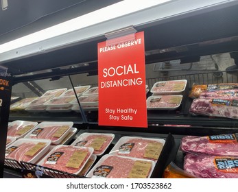 Portland, OR / USA - April 12 2020: Social distancing reminder on a sign hanging in the grocery store during coronavirus pandemic.