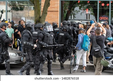 Portland, OR / USA - August 17 2019: Large Group Of Police Officers In Riot Gear Breaking Up Fight In Downtown During Antifa Demonstration.