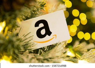 Portland, OR / USA - December 12, 2019: Amazon logo gift card in pine tree with holiday theme background