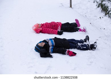 Portland, OR / USA - December 15 2016: Kids Playing Outside In Snow Doing Snow Angel.