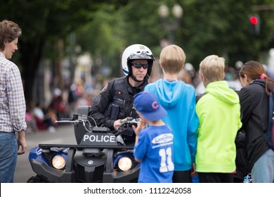 Portland, OR / USA - June 11 2016: Police Officer On A Bike Interacting With Kids At Grand Floral Parade