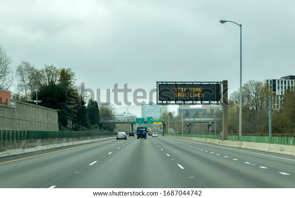 Portland, OR / USA - March 29 2020: Electronic\
sign on i84 freeway notifying people to stay home and save lives by\
reducing the risk of being infected or getting the coronavirus\
COVID-19 virus.