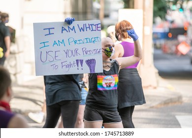 Portland, OR / USA - May 29 2020: Teenage protester holding sign "I am white, I am Privileged, Use your privilege to fight" during downtown demonstration.