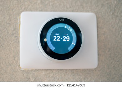 Portland, OR / USA - October 27 2018: Nest thermostat on the the textured wall showing degrees in Celsius.