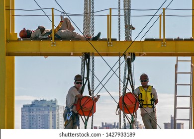 Porto Alegre/Rio Grande do Sul/Brazil - 01/10/2012: A worker rests while two others stand in a construction site