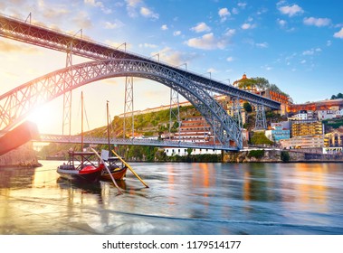 Porto old town, Portugal. Evening sunset with sunshine. Panoramic view at Ponte de Dom Luis on Douro river. Medieval monastery fort Mosteiro da Serra do Pilar. Traditional boats with port wine.