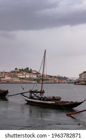 PORTO, PORTUGAL – APRIL 24, 2020: Traditional and Iconic Rabelo Boats moored in Douro River - Cloudy Sky with Rain 