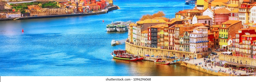 Porto, Portugal old town ribeira aerial promenade view with colorful houses, Douro river and boats, banner panoramic view