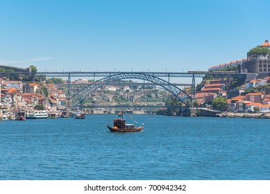 Porto, Portugal, panorama of Dom Luis bridge, the river Douro and a traditional boat
