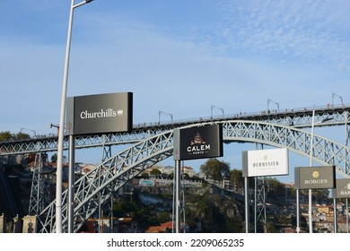 Porto, Portugal, September, 17, 2022, Signs Displaying Port Houses In Porto, The Dom Luis 1 Bridge Can Be Seen In The Background. 