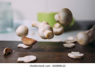Portobello champignon in a wooden bowl and cutting board on a kitchen table