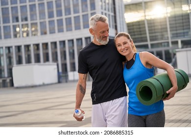 Portrail of sporty mature couple, man and woman in sportswear walking together in the city after morning training - Powered by Shutterstock