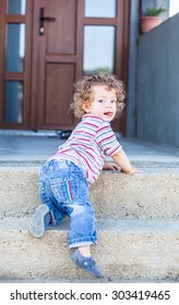 Portrait Of 1 Year Old Baby Boy Climbing Down The Stairs.
