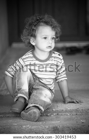 Similar – Cute little boy seated on the wall of a castle