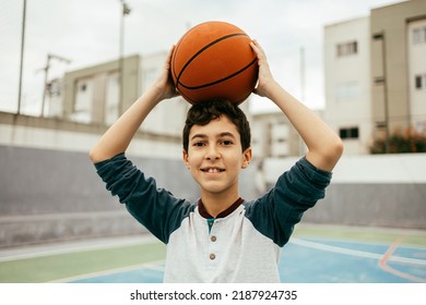 Portrait Of 12 Year Old Boy With Basketball. Teenager Training Basketball Outdoors.