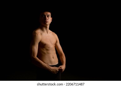 Portrait Of A 19 Year Old Shirtless Teenage Boy On A Black Background