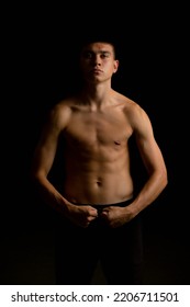 Portrait Of A 19 Year Old Shirtless Teenage Boy On A Black Background