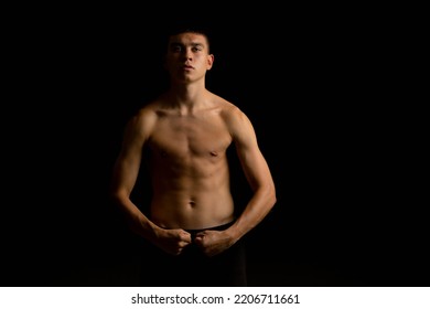 Portrait Of A 19 Year Old Shirtless Teenage Boy On A Black Background