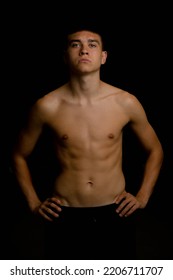 Portrait Of A 19 Year Old Shirtless Teenage Boy On A Black Background