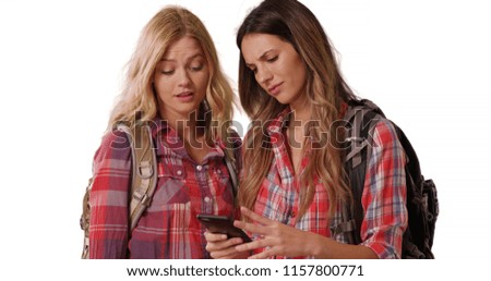 Portrait of 2 female hikers using phone to navigate location on white copy space