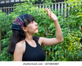 Portrait 20-25-year Girl Asian Woman With Long Black Hair Wearing Black Shirt, Blue Jeans, Acne Scars Faces, Standing In  Garden Tree. Spring Or Summer In The Evening Of The Day At Bangkok Thailand

