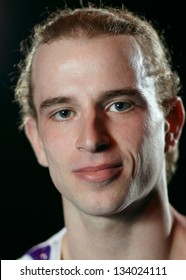 Portrait Of 25 Year Old Man Looking To The Photographer. Close Up Portrait On Black Background.