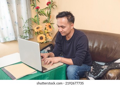 Portrait Of A 30 Year Old Man Man Typing On His Laptop. Thinking Happy Thoughts. Encoding Data On A Computer.