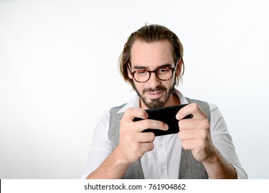 Portrait Of A 30 Years Old Nerd Geek Playing Game App On A Smartphone Isolated On White Background 