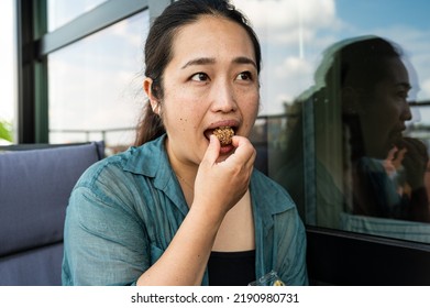 Portrait Of A 32 Year Old Japanese Woman Eating Chocolate, Brussels