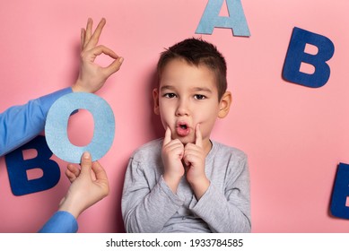 Portrait Of A 4 Year Old Boy  Speech Therapy Concept On Pink  Background. Correct Pronunciation And Articulation At Preschool Age.