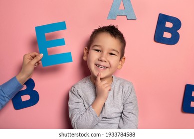 Portrait Of A 4 Year Old Boy  Speech Therapy Concept On Pink  Background. Correct Pronunciation And Articulation At Preschool Age.