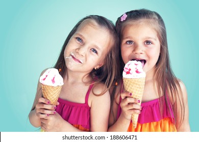 Portrait Of 5 Years Old Kid Girls Eating Tasty Ice Cream Over Blue