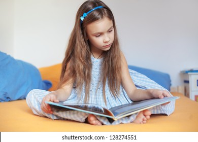 Portrait Of 6 Years Old Child Reading Book At Home