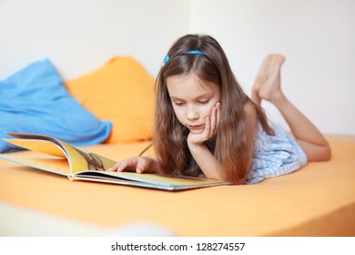 Portrait Of 6 Years Old Child Reading Book At Home